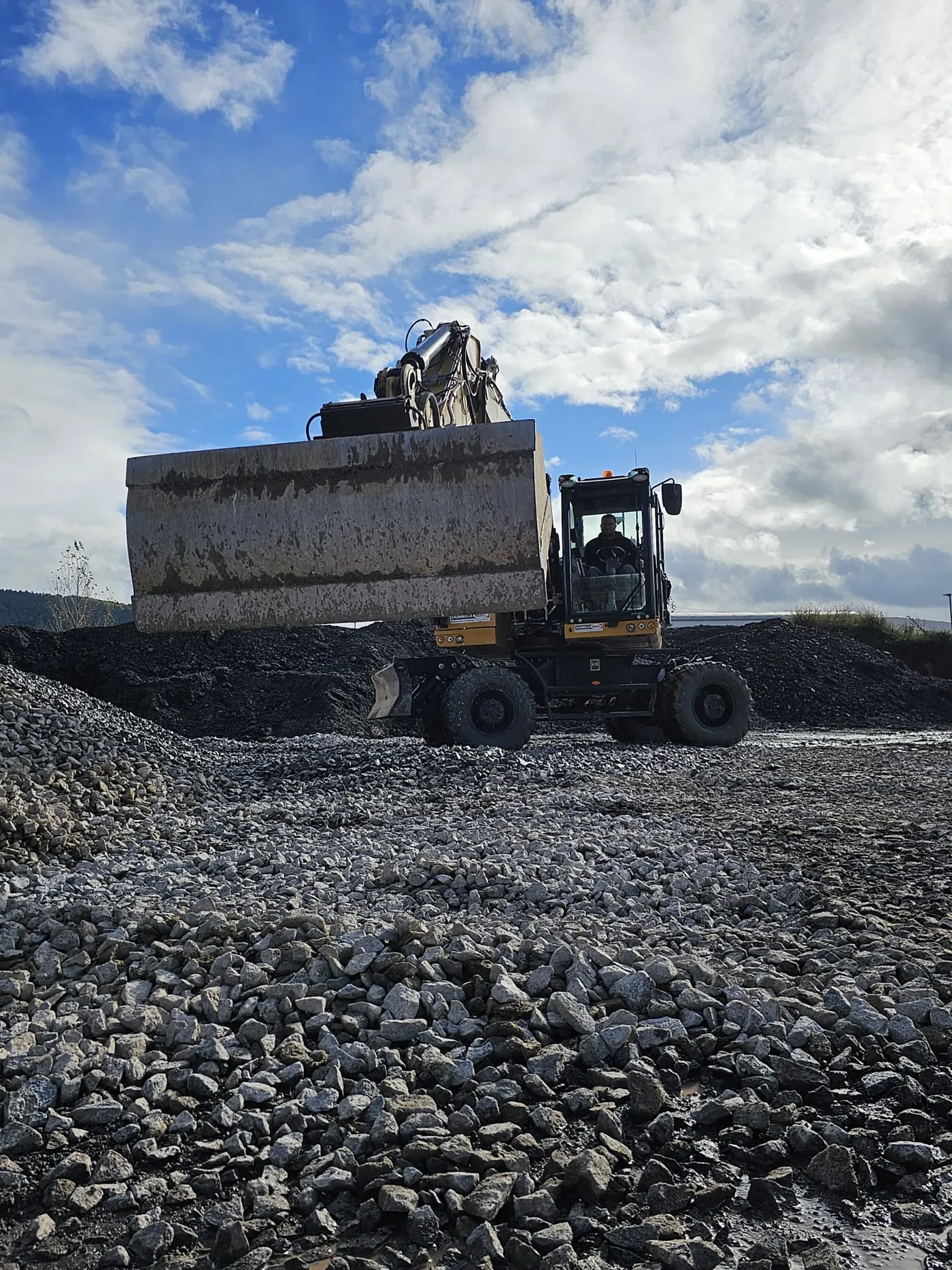 Bagger hebt ein Betonelement bei Abbrucharbeiten