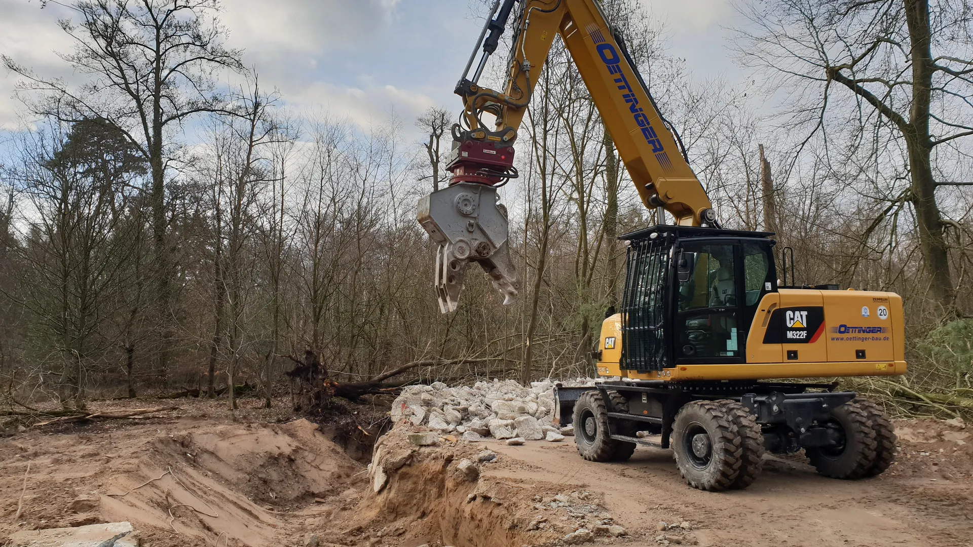 Mobilbagger mit Greifer bei Forstarbeiten am Waldrand